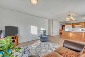 Carpeted living room with ceiling fan