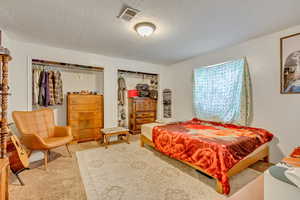 Bedroom with light carpet and a textured ceiling