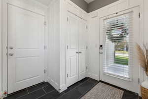 Entryway with dark tile patterned flooring