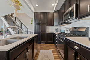 Kitchen featuring subway tile backslash, an island with sink, a breakfast bar area, and appliances with stainless steel finishes