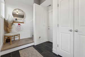 Mudroom with dark tile patterned floors