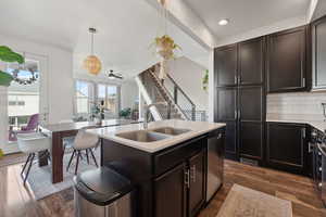 Kitchen featuring subway tile backslash, an island with sink, a breakfast bar area, and appliances with stainless steel finishes