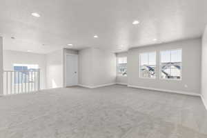 Spare room with light carpet and a textured ceiling