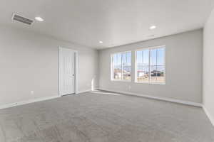 Carpeted empty room with a textured ceiling