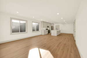 Unfurnished living room with light wood-type flooring and sink