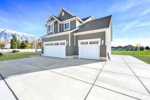 Craftsman inspired home with a mountain view, a garage, and a front yard