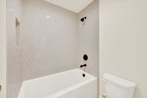 Bathroom featuring toilet and tiled shower / bath