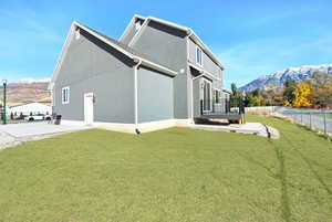 Back of property featuring a mountain view and a yard