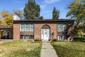 Raised ranch featuring a front yard and a carport