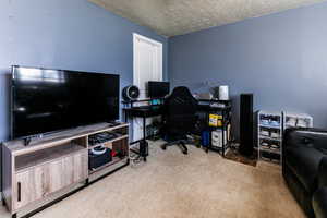 Carpeted office space featuring a textured ceiling