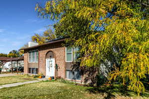 View of front of property with a carport and a front yard