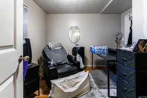 Office area with hardwood / wood-style floors and a textured ceiling