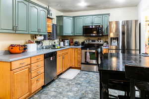 Kitchen featuring sink, stainless steel appliances, and a textured ceiling