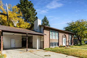 View of front of house with a front lawn and a carport