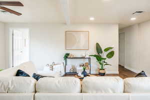 Living room with hardwood / wood-style flooring, ceiling fan, and beamed ceiling