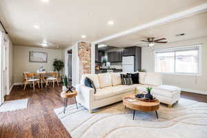 Living room with ceiling fan, sink, and dark wood-type flooring