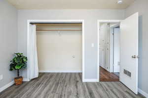 Unfurnished bedroom with hardwood / wood-style flooring and a closet