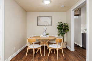 Dining area with a textured ceiling and dark hardwood / wood-style floors