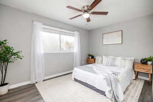 Bedroom with hardwood / wood-style floors and ceiling fan