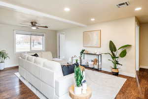 Living room featuring ceiling fan and dark hardwood / wood-style flooring