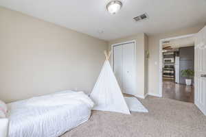 Bedroom featuring a closet, white refrigerator, and hardwood / wood-style flooring