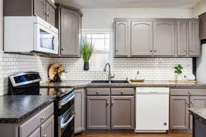 Kitchen featuring white appliances, gray cabinets, and sink