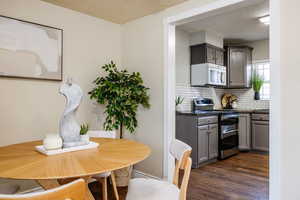 Dining area featuring dark wood-type flooring and a textured ceiling