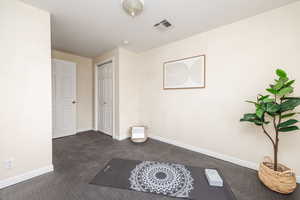 Spare room featuring dark colored carpet