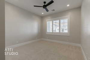 Carpeted empty room featuring ceiling fan