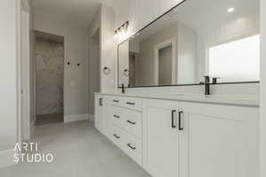 Bathroom with a tile shower, vanity, and tile patterned floors