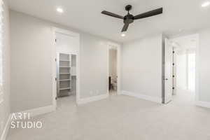 Unfurnished bedroom with a closet, a walk in closet, ensuite bathroom, and ceiling fan