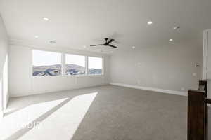 Carpeted spare room with a mountain view and ceiling fan