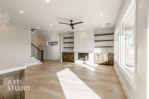 Unfurnished living room with a fireplace, light hardwood / wood-style floors, and ceiling fan