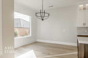 Unfurnished dining area with light hardwood / wood-style flooring and an inviting chandelier