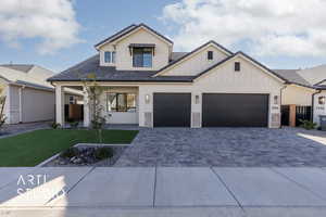 View of front facade featuring a garage and a front lawn