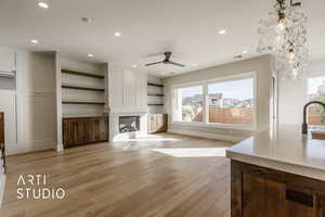 Unfurnished living room with a fireplace, light hardwood / wood-style floors, a wealth of natural light, and ceiling fan