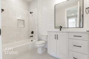 Full bathroom featuring tile patterned floors, toilet, vanity, and tiled shower / bath