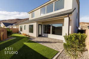 Back of property with a lawn and a patio area