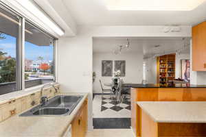 Kitchen featuring backsplash, kitchen peninsula, sink, and light tile patterned floors