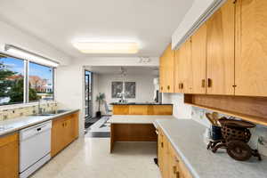 Kitchen featuring dishwasher, kitchen peninsula, and sink