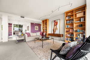 Carpeted living room with track lighting