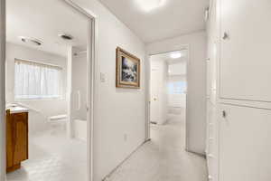 Hallway featuring light tile patterned floors and tile walls