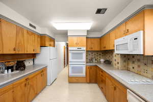 Kitchen featuring white appliances and backsplash