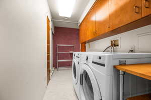 Washroom featuring cabinets and independent washer and dryer