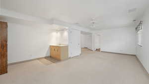 Carpeted empty room with ceiling fan and sink