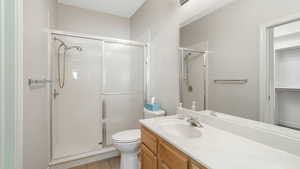 Bathroom featuring tile patterned floors, toilet, vanity, and walk in shower