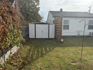 View of outbuilding featuring a lawn