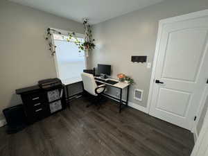 Office area featuring dark wood-type flooring