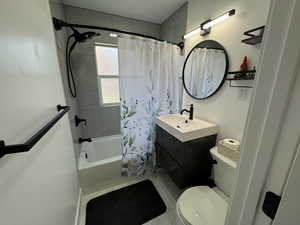 Full bathroom featuring tile patterned flooring, vanity, shower / bath combo, and toilet