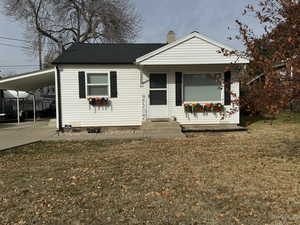 View of front of property with a front lawn and a carport